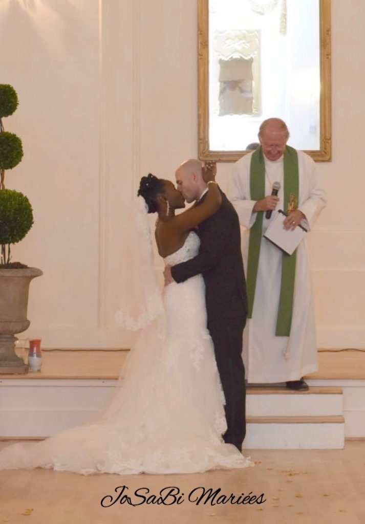 Deborah kissing her groom in a custom wedding dress by JoSaBi Mariées