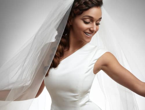 Bride smiling in a one shoulder neckline wedding dress on the JoSaBi blog