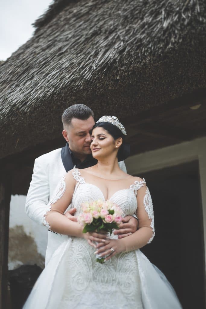 Bride wearing an illusion wedding dress hugging her groom