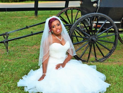 Bride sitting in the grass in a sweetheart wedding dress neckline